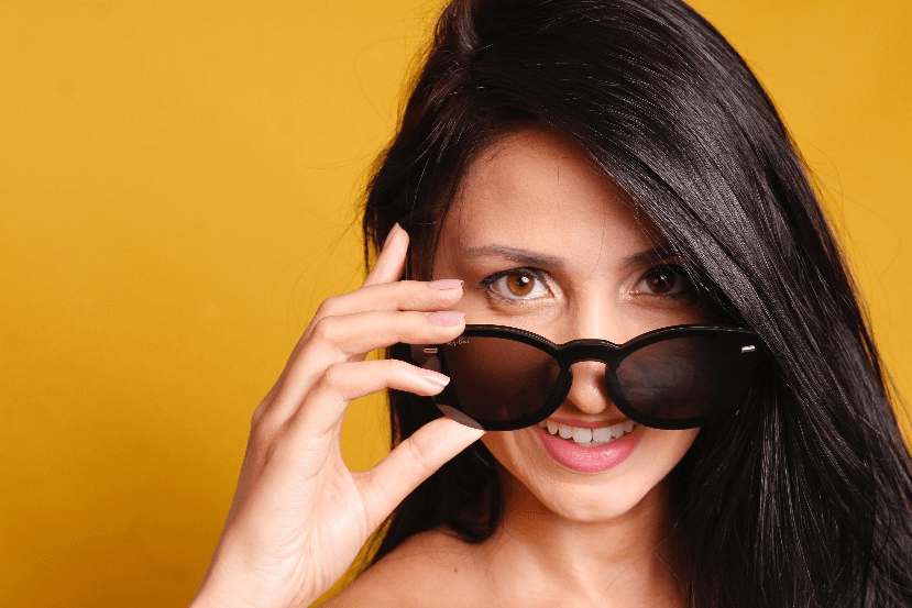 A smiling person wearing black sunglasses.