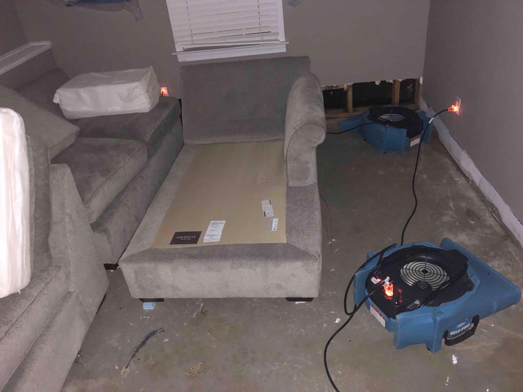 A grey sofa set is disassembled with dryers plugged in