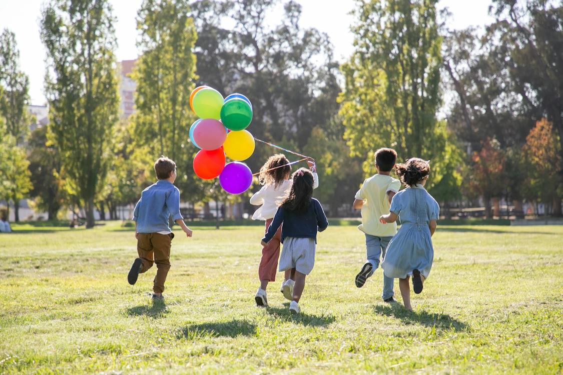Children playing with balloons in a community park