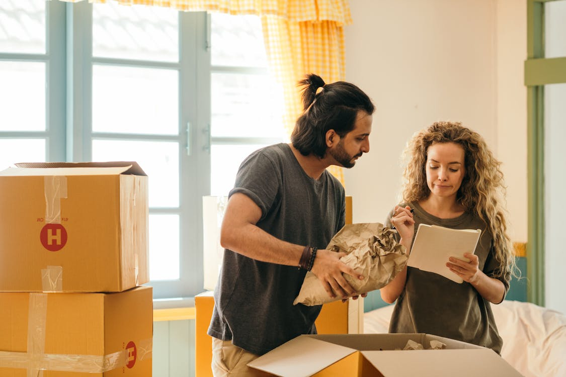  A moving couple packing boxes through a list