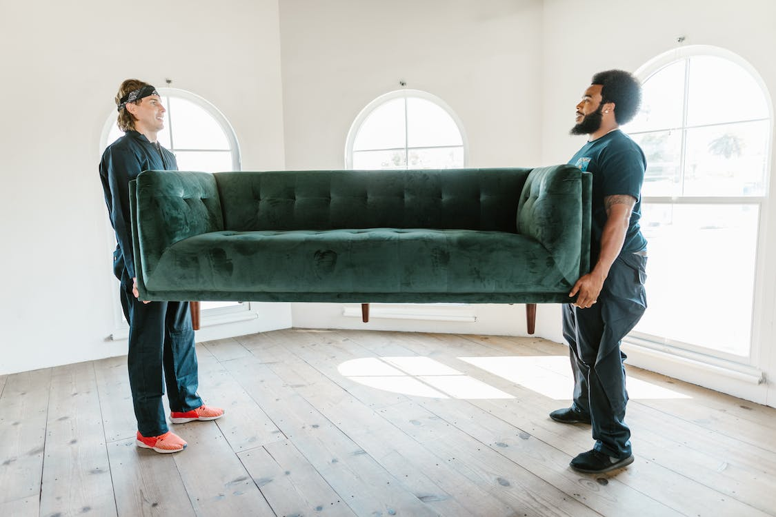Professional movers transporting a couch long-distance