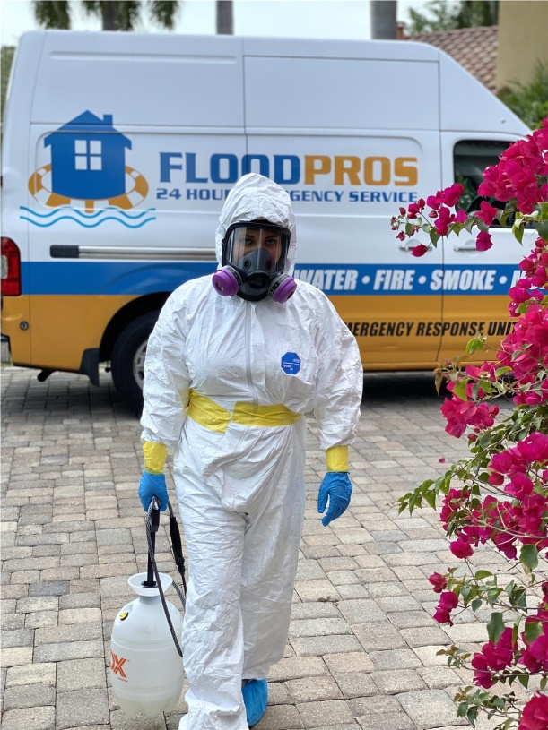 Water extraction expert in protective gear removing water from a flooded area