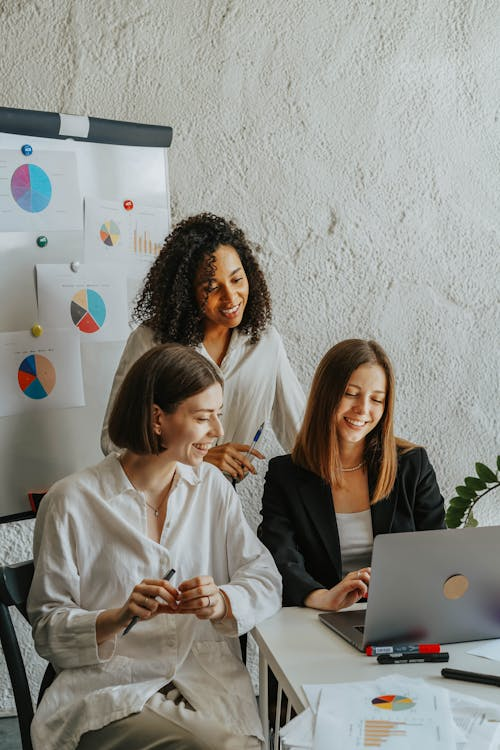 three people looking at a laptop