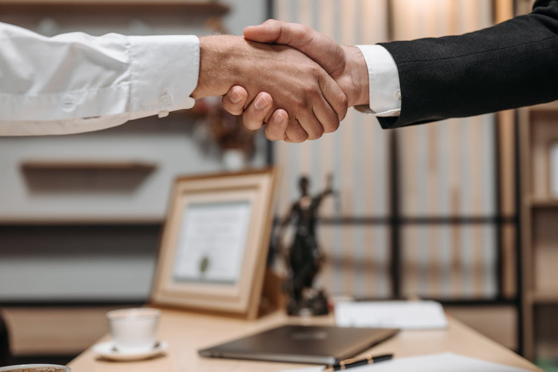 A close-up photo of two people shaking hands