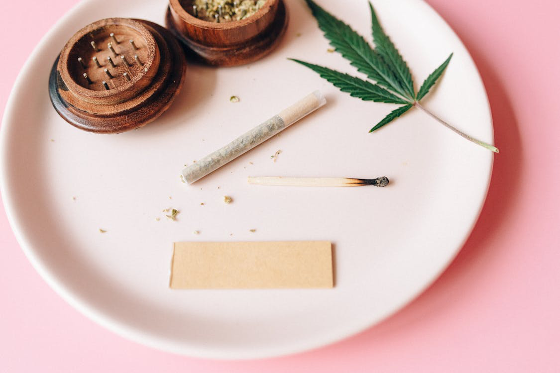 Cannabis roll and a matchstick on a plate